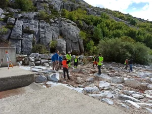 Equipo técnico realizando trabajos de restauración fluvial y recuperación de un cauce en un entorno natural de montaña.